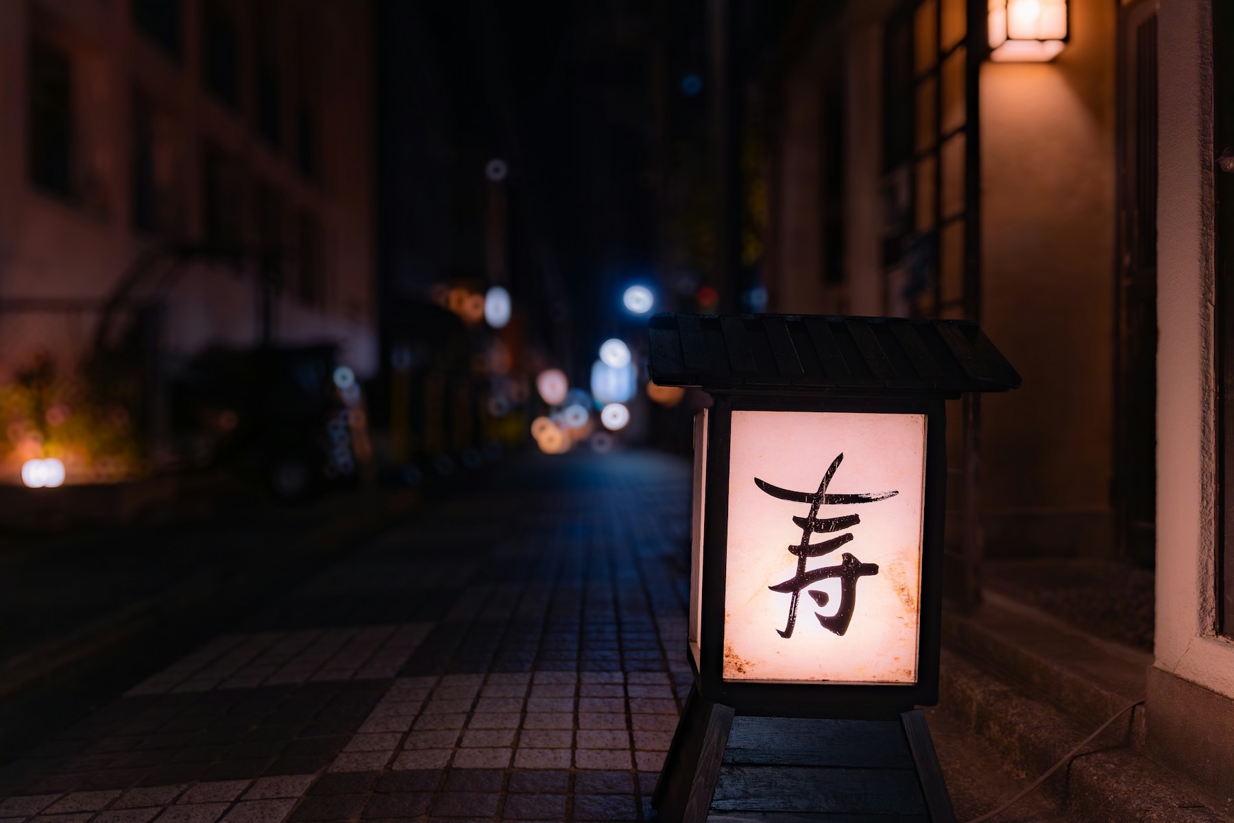 Lanterna iluminada numa rua noturna de Kagurazaka.